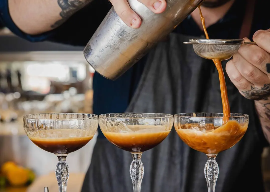 A Mudbar mixologist pouring espresso martinis